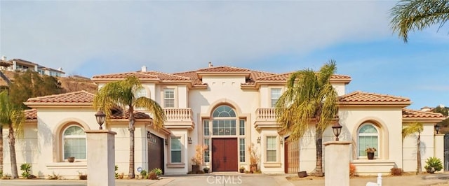 mediterranean / spanish house with a tiled roof and stucco siding