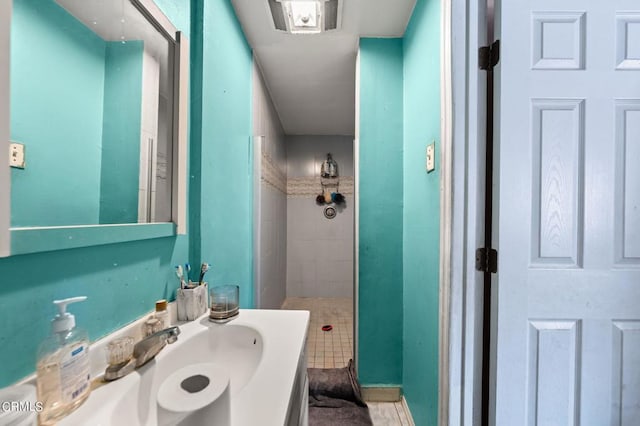 bathroom featuring vanity, tile patterned floors, and tiled shower