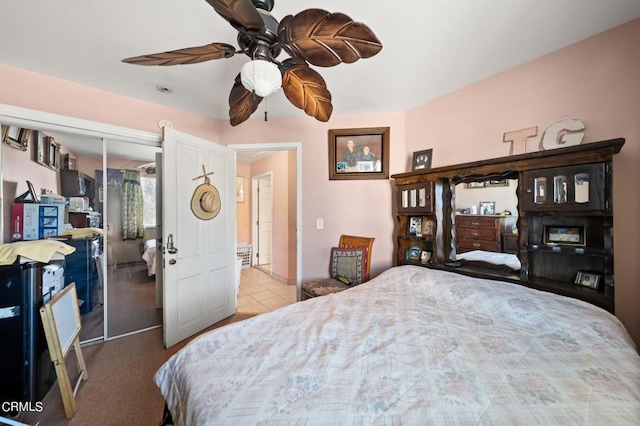 tiled bedroom with ceiling fan and a closet