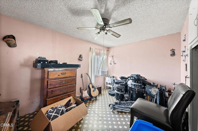 miscellaneous room with ceiling fan and a textured ceiling