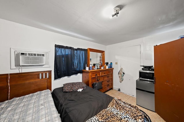 bedroom featuring light tile patterned floors, an AC wall unit, and stainless steel fridge