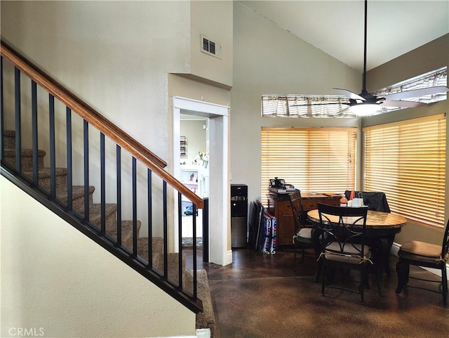 dining area with ceiling fan and a high ceiling