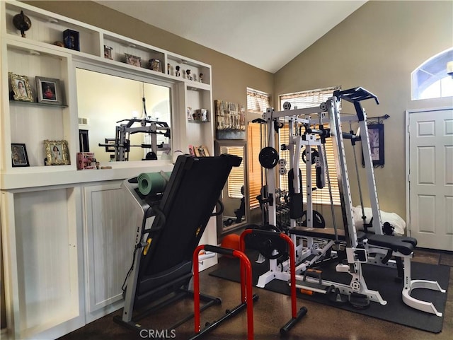 workout room featuring lofted ceiling, plenty of natural light, and a chandelier