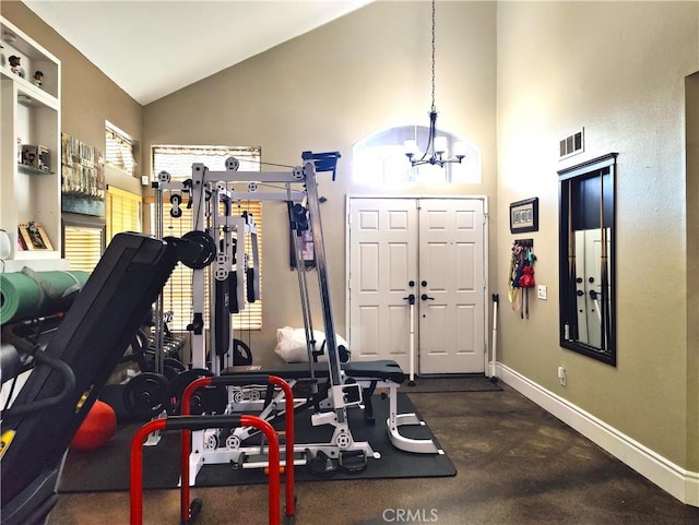 exercise room with an inviting chandelier and high vaulted ceiling