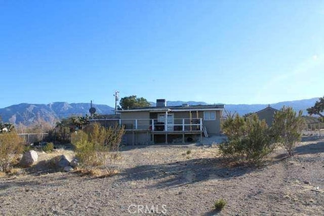 rear view of property with a deck with mountain view