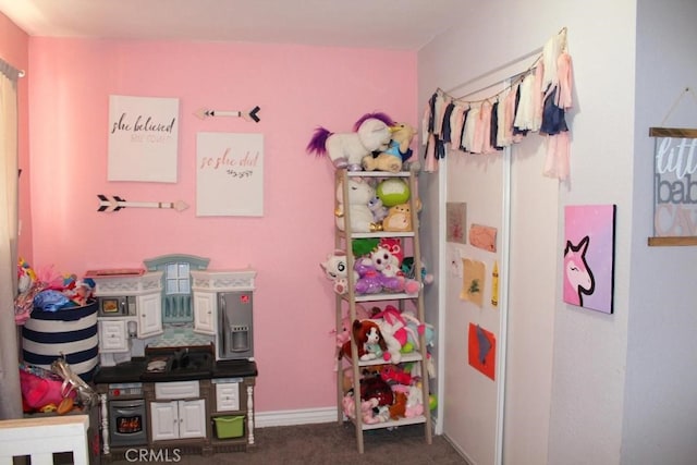 playroom featuring dark colored carpet