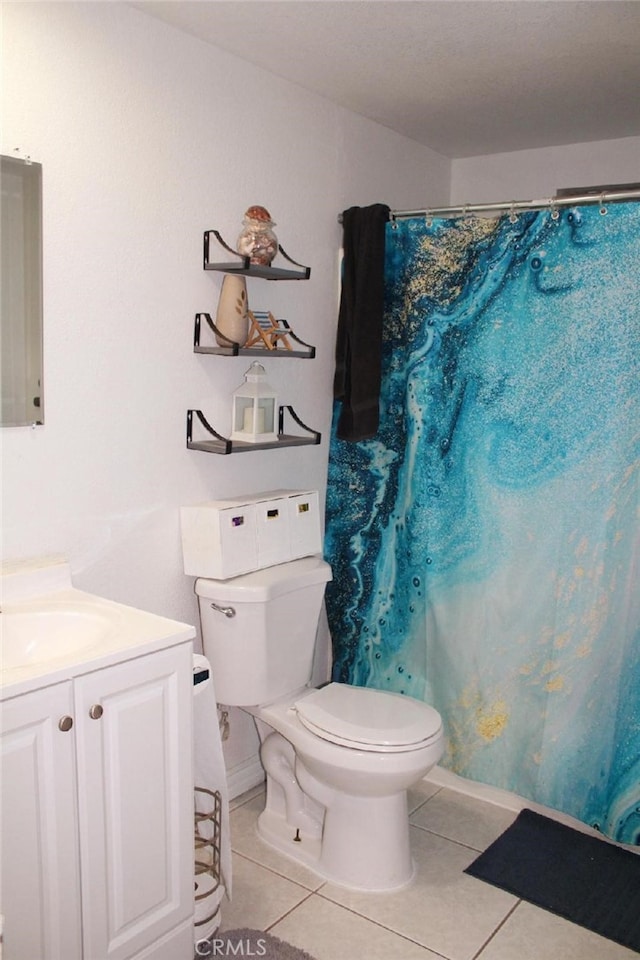 bathroom with tile patterned flooring, vanity, and toilet