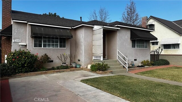 view of front facade with a patio area and a front yard