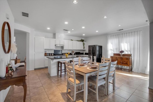 tiled dining room featuring sink