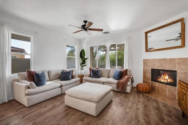 living room featuring ceiling fan, a fireplace, and hardwood / wood-style floors