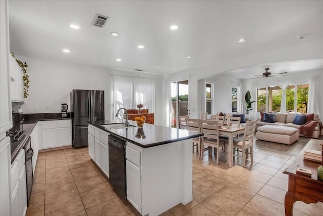 kitchen with white cabinetry, an island with sink, ceiling fan, dishwasher, and refrigerator