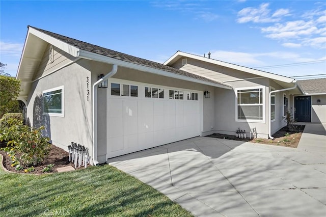 ranch-style house featuring a garage and a front lawn