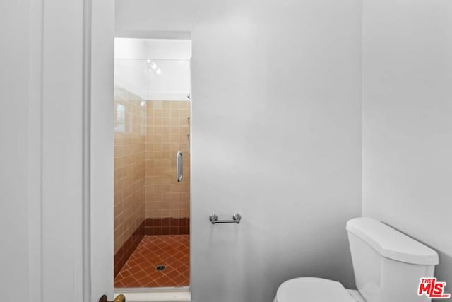 bathroom with toilet and an enclosed shower