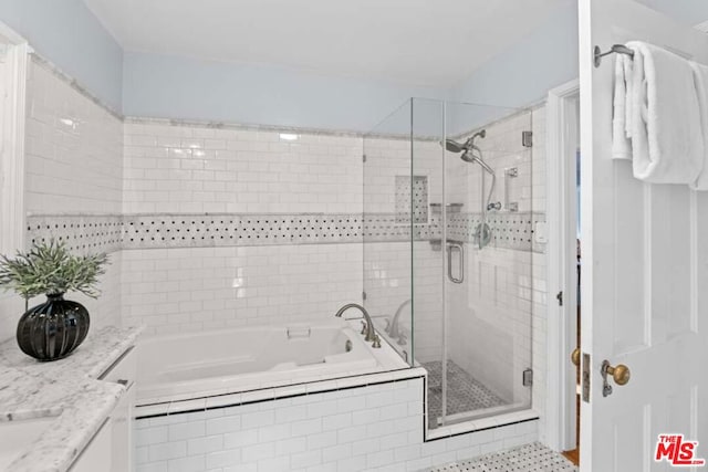 bathroom with vanity and independent shower and bath