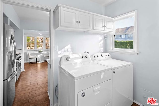 laundry room with cabinets, washer and clothes dryer, and plenty of natural light