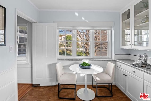 dining room with breakfast area, ornamental molding, a healthy amount of sunlight, and dark hardwood / wood-style flooring