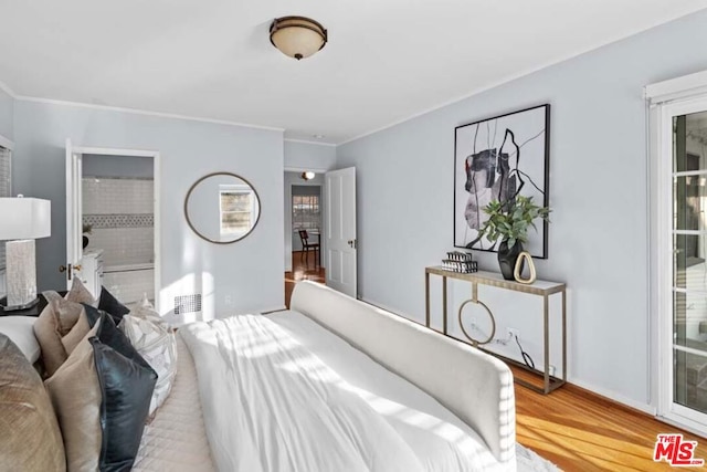 bedroom featuring wood-type flooring and ensuite bath