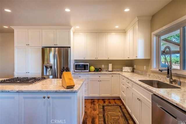 kitchen with dark hardwood / wood-style floors, sink, white cabinetry, stainless steel appliances, and light stone counters