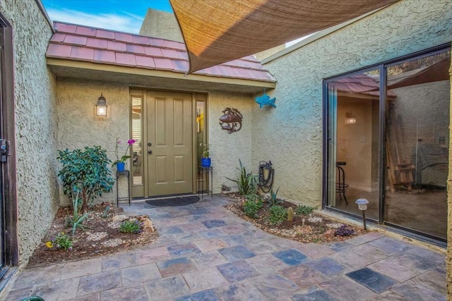 entrance to property featuring a patio