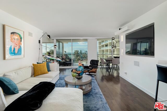 living room featuring dark wood-type flooring and expansive windows