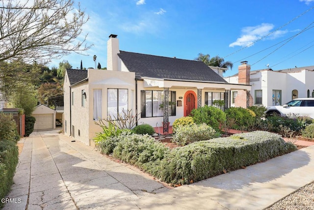 view of front of house featuring a garage and an outbuilding