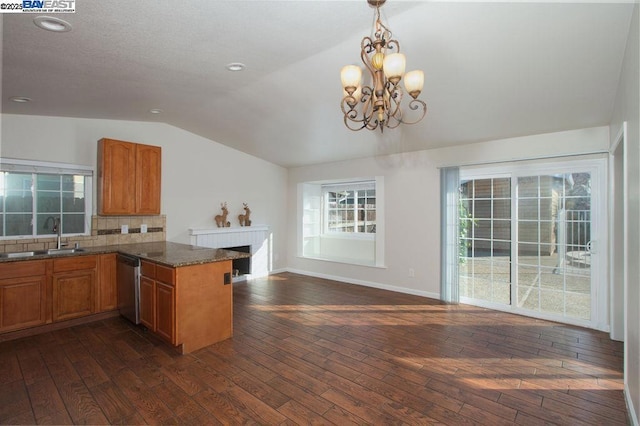 kitchen with dishwasher, sink, kitchen peninsula, a notable chandelier, and vaulted ceiling