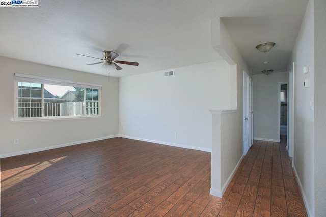 empty room with ceiling fan and dark hardwood / wood-style flooring