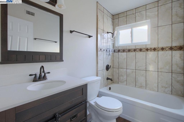 full bathroom featuring toilet, vanity, and tiled shower / bath combo