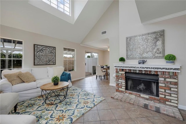 tiled living room with crown molding, a fireplace, plenty of natural light, and high vaulted ceiling