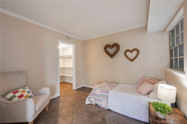 bedroom featuring a closet, a walk in closet, and crown molding