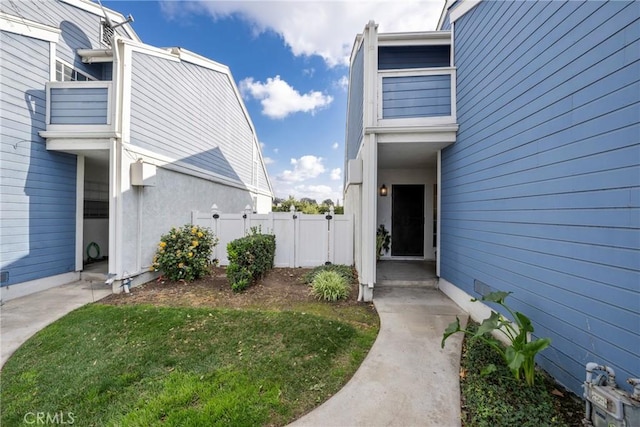 property entrance with a lawn