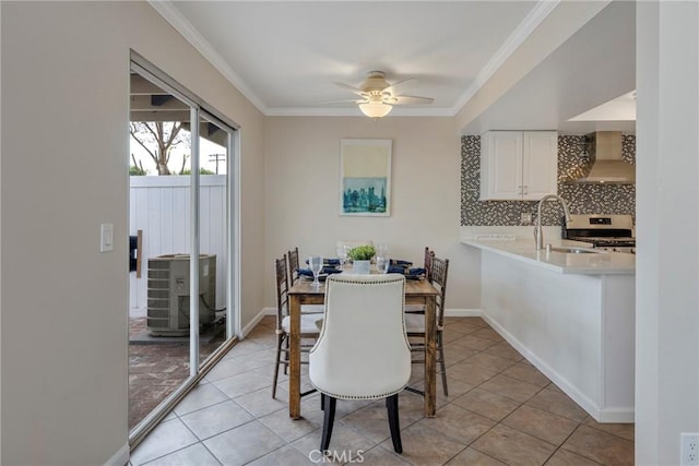 dining area featuring ceiling fan, light tile patterned floors, ornamental molding, and sink