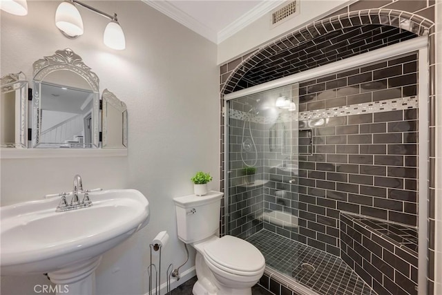 bathroom featuring sink, toilet, walk in shower, and ornamental molding