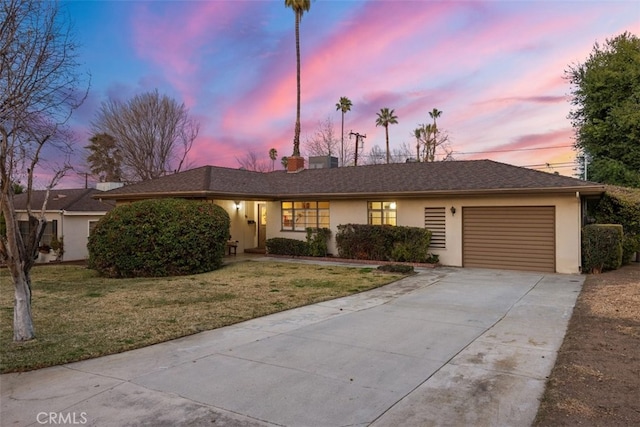 ranch-style house with a yard and a garage