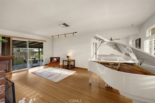 misc room featuring ceiling fan, rail lighting, and hardwood / wood-style floors