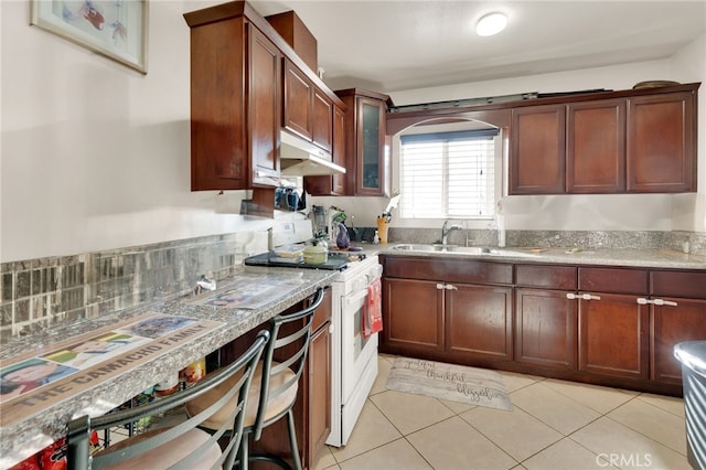 kitchen featuring light tile patterned floors, backsplash, sink, and white range oven