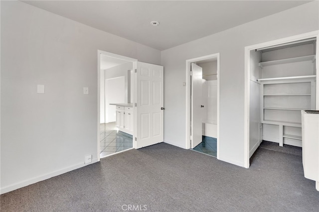 unfurnished bedroom featuring dark colored carpet and a closet