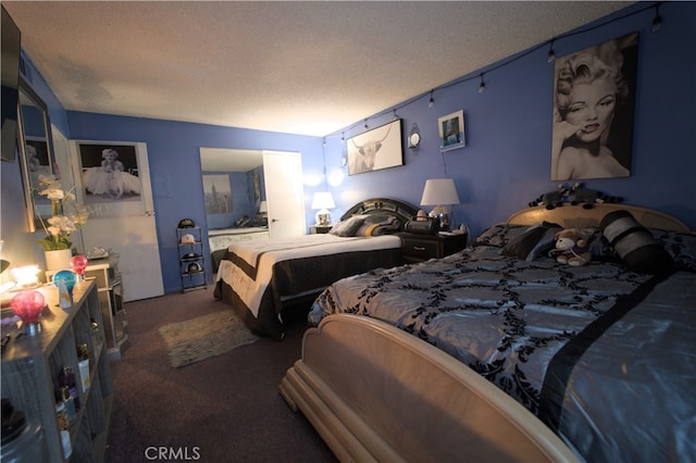 bedroom with dark carpet and a textured ceiling