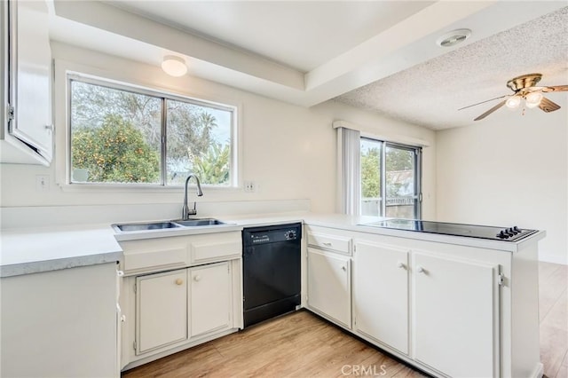 kitchen featuring sink, kitchen peninsula, white cabinets, and black appliances