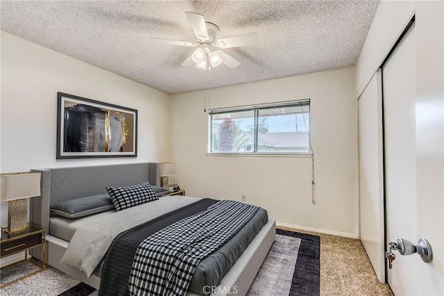 carpeted bedroom with ceiling fan, a textured ceiling, and a closet