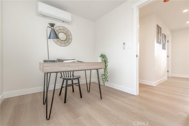 office space featuring an AC wall unit and light hardwood / wood-style floors