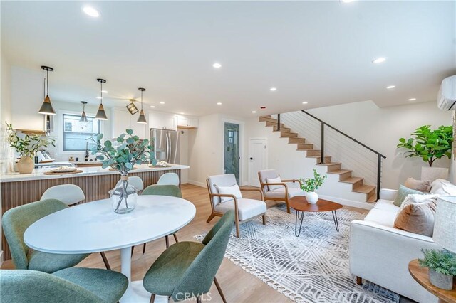 dining space featuring an AC wall unit and light wood-type flooring