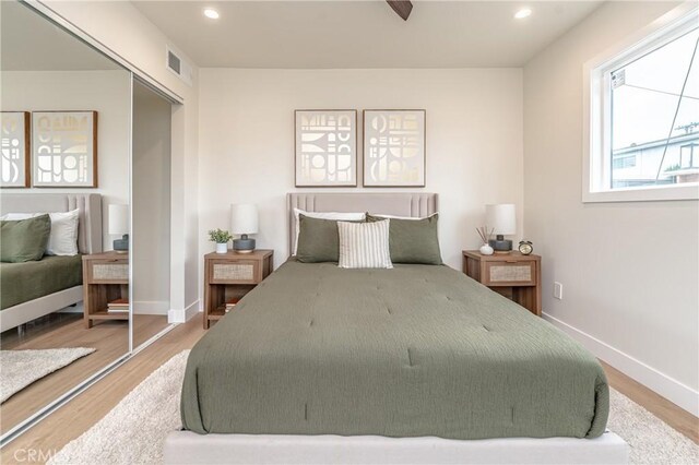 bedroom with hardwood / wood-style floors, a closet, and ceiling fan