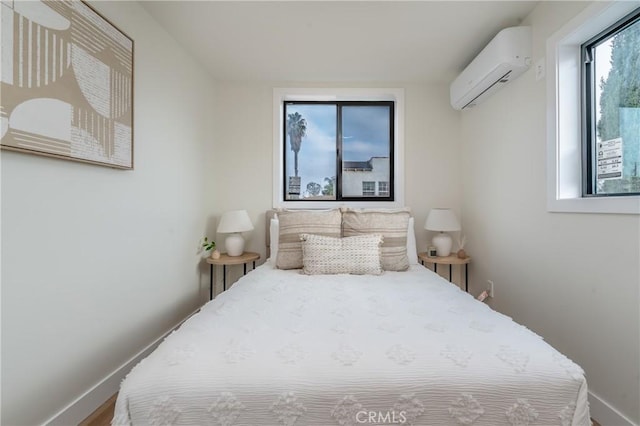 bedroom featuring hardwood / wood-style floors and a wall unit AC