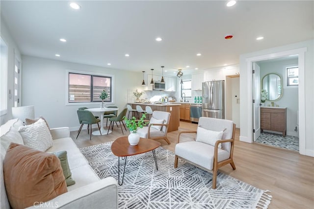 living room featuring sink and light hardwood / wood-style floors