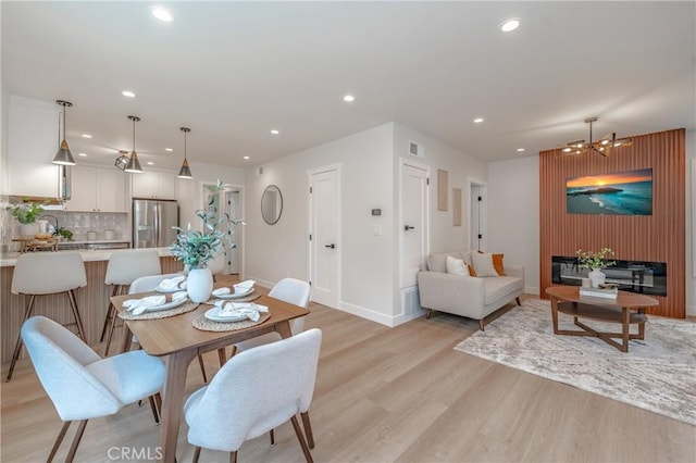 dining room with a chandelier and light wood-type flooring