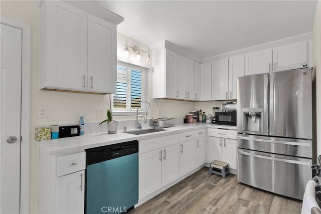 kitchen featuring appliances with stainless steel finishes, sink, and white cabinets