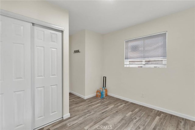 unfurnished bedroom featuring light hardwood / wood-style flooring and a closet