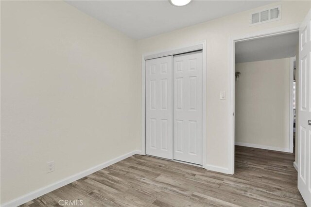 unfurnished bedroom with light hardwood / wood-style floors and a closet