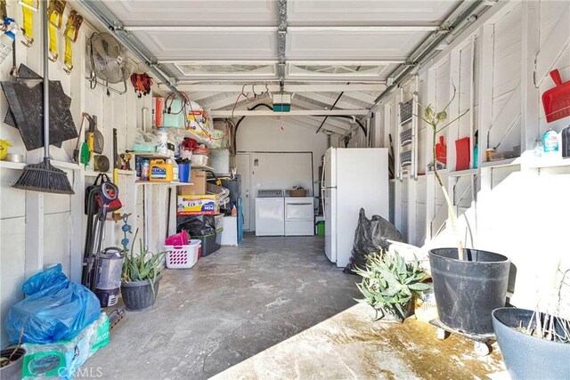 garage with washer and clothes dryer and white fridge